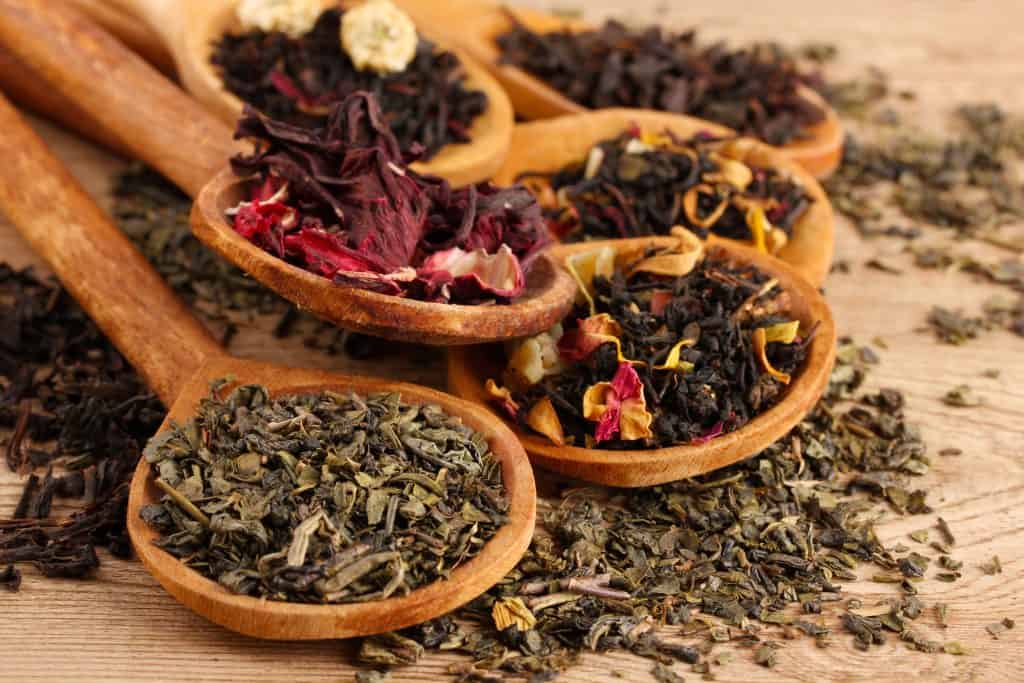 Loose leaf tea in wooden spoons.