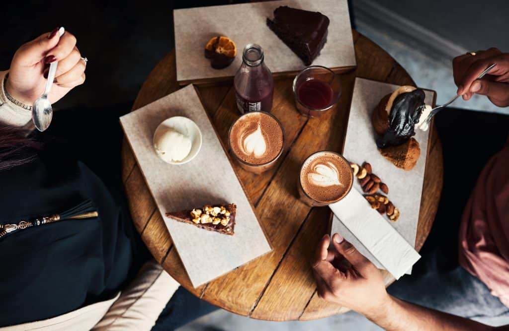 Aerial view of plates with dessert and coffee cups. 